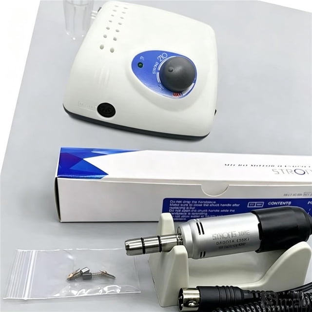 micromotor profesional 35000 rpm para manicura y tallado 210+108e, pieza de mano tipo e, motor eléctrico 65w compatible con voltaje méxico 110-220v Pieza de mano tipo E plateada con conector 2.35 mm apoyada en soporte, accesorios en bolsa transparente y unidad base blanca con perilla de control azul y LED al fondo. Carcasa plástica y cuerpo metálico visibles; indicado para limado y pulido de uñas y adecuado también para tallado y pulido de piezas pequeñas como joyería o resina.