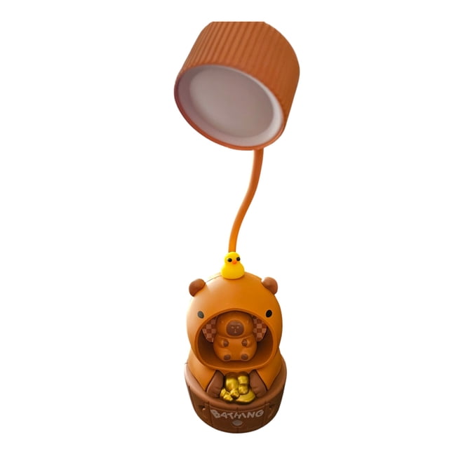 lámpara capibara mesa escritorio 2en1 sacapuntas, recargable lámpara de mesa con figura de capibara marrón; base redondeada con sacapuntas frontal y compartimento inferior, cuello flexible naranja y pantalla cilíndrica acanalada; patito amarillo sobre la cabeza; fondo blanco.