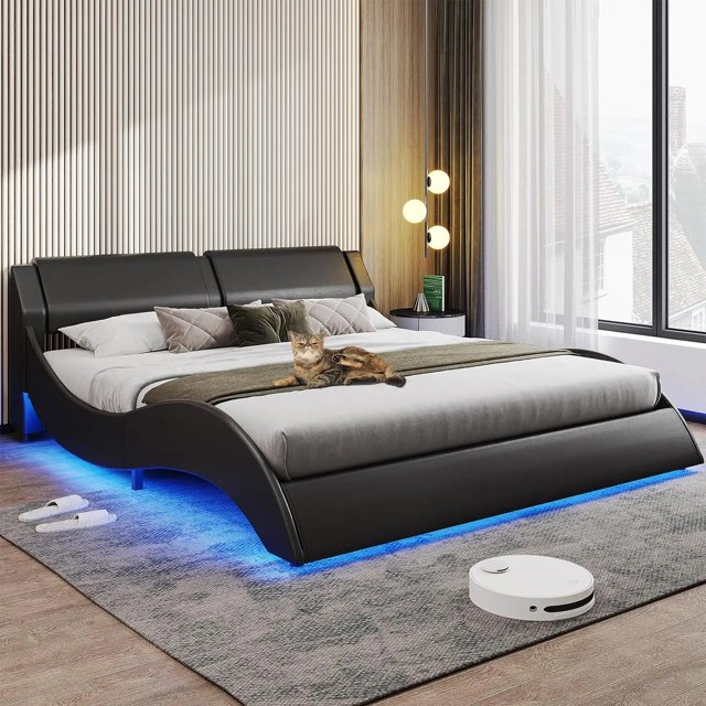 bed frame, large with headboard, modern upholstered platform, led bed frame, with led lights, wavy curve,large thin platform bed Azul by My Lux Decor vista frontal centrada de un marco de cama grande y moderno con cabecera acolchada y silueta baja de plataforma ondulada; tira de luces RGB visible bajo la base mostrando tono azul, textura acolchada del tapizado, plataforma delgada con base empotrada para colchón, cojines decorativos y manta doblada, gato recostado en el centro; ambiente de recámara con lámpara de pie, cortinas translúcidas, ventana con vista y robot aspirador en el piso. A menudo usado como pieza central en recámaras modernas.