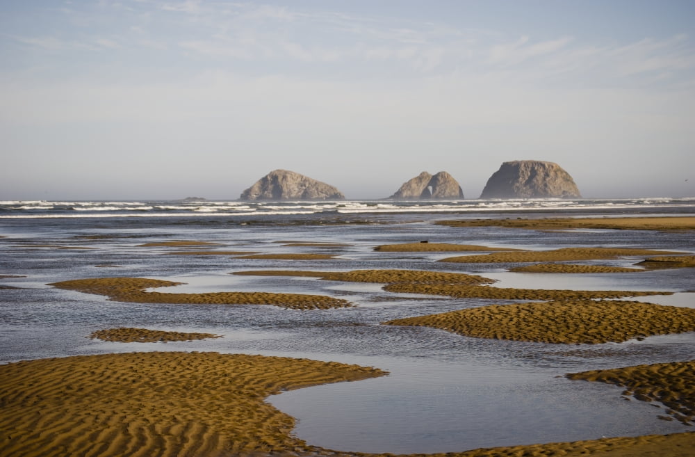 Three Arch Rocks are viewed from the mouth of Netarts Bay; Netarts
