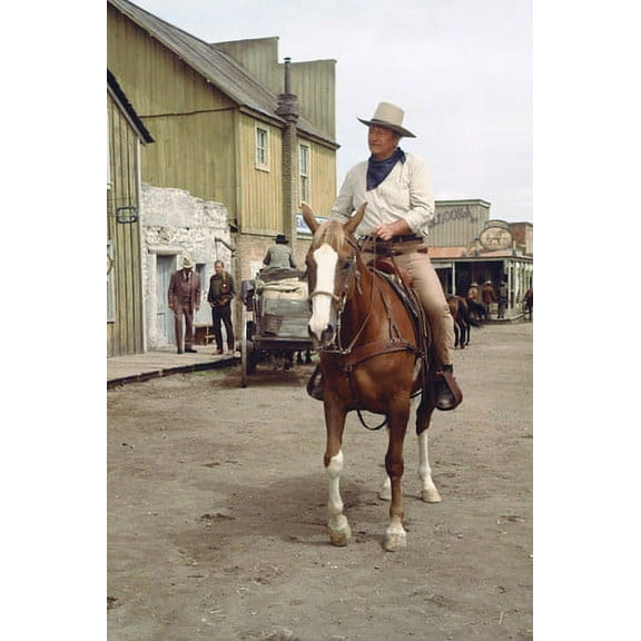 John Wayne in Chisum riding into western town on horse 24x36 Poster