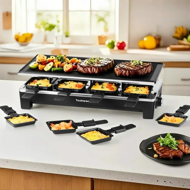 Techwood 2-in-1 Raclette & Korean BBQ Grill, a black 1500W electric table grill with a reversible non-stick cooking surface and eight individual cheese pans. The grill is displayed on a kitchen counter with sizzling steaks, grilled vegetables, and melted cheese in pans, perfect for interactive cooking at parties and family gatherings. Removable plates ensure easy cleaning and are dishwasher-safe.