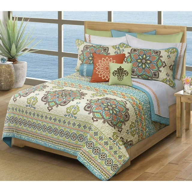 Safdie & Co. Home Deluxe Collection Multi Color 100% Polyester Quilt Set on a wooden bed frame with a waterfront view. The twin quilt features a printed quilted coverlet with floral and geometric patterns in blue, orange, green, and brown on cream. Includes two matching pillow shams and coordinating decorative pillows. The 66 by 86 inch quilt is 100% polyester microfiber and machine washable, suitable for adding softness and style to a bedroom.
