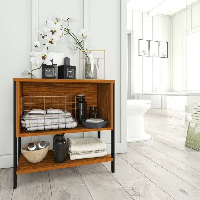 estante organizador playcon 2 vistas 3 niveles 60x60 cm tzalam estantería compacta de dos niveles color madera naranja tzalam con estructura metálica negra con recubrimiento PVC, vista frontal 3/4; muestra toallas dobladas, canasta metálica y accesorios en los estantes, patas delgadas y tablero superior para decoración, ideal para almacenaje en baño o cuarto de lavado.
