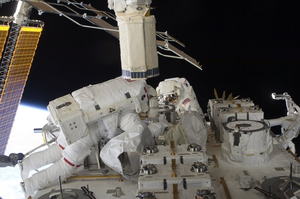 Astronauts working on the International Space Station during a spacewalk Stretched Canvas