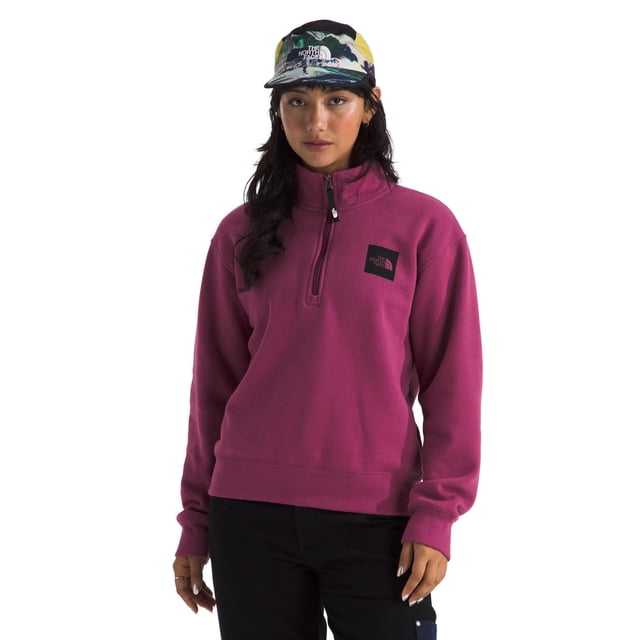 chaqueta the north face box half dome con cierre ¼ para mujer Cyber Berry, vista frontal centrada de modelo de pie con cremallera de 1/4 hasta cuello alto, logo Box Half Dome en el pecho, puños y dobladillo acanalados, silueta de ajuste estándar hasta la cadera y tejido polar liso; suele emplearse como capa intermedia ligera para actividades al aire libre.
