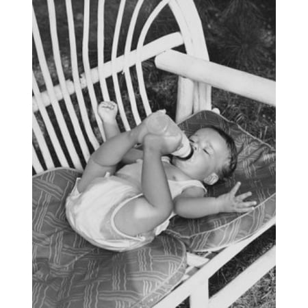High angle view of a baby lying on a couch and drinking milk from a bottle Stretched Canvas -  (18 x