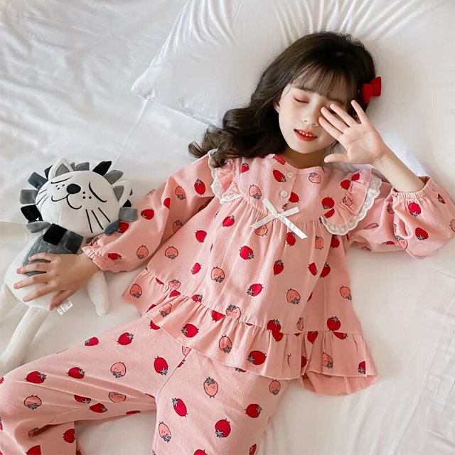 pijamas de algodón de manga larga para niñas y niños, ropa de dormir para niñas, conjuntos de pijamas para adolescentes, trajes de noche para niños Conjunto rosa de pijama de dos piezas con estampado de fresas tipo dibujos animados; vista cenital de niña recostada sobre cama blanca, blusa de cuello redondo con volante y lazo frontal, mangas largas con puños elásticos y pantalón largo de cintura elástica; tela peinada indicada, tallas 110-170 cm; a menudo usado también como ropa cómoda para descanso en casa.