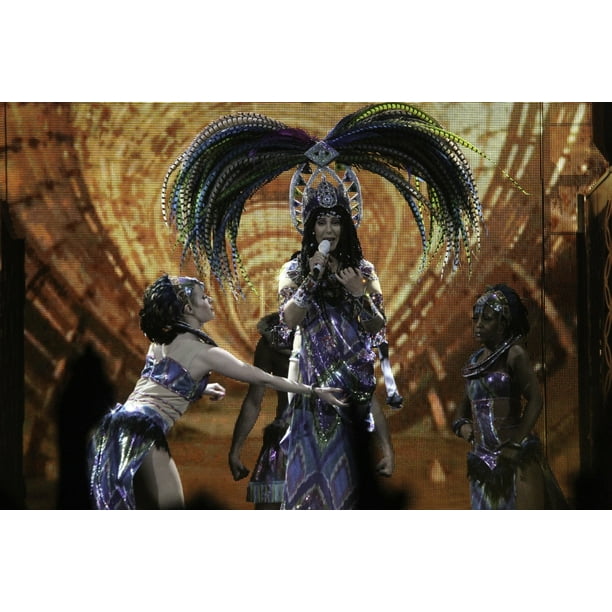 Cher wearing a feather headdress performing in the Dressed To Kill tour