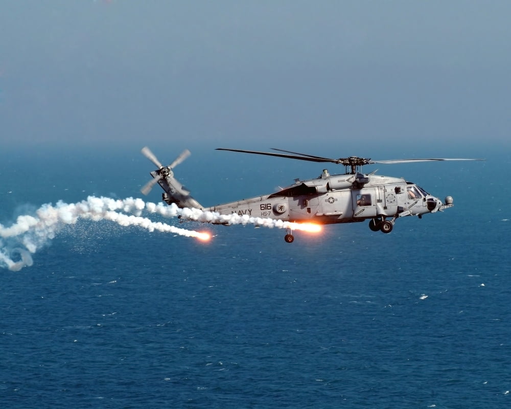A U.S. Navy HH 60H Seahawk Helicopter dispenses flares and chaff Poster Print (31 x 25)