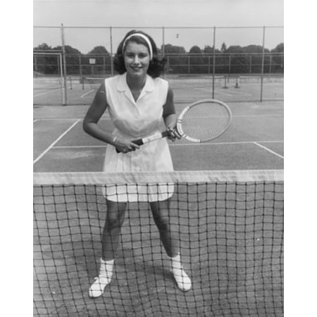 Young woman standing on a tennis court and holding a tennis racket Stretched Canvas -  (24 x