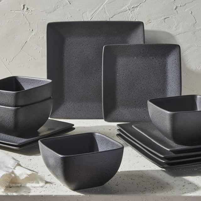 Better Homes & Gardens Anderson grey square-shaped stoneware 12-piece dinnerware set with plates and bowls displayed on a light textured surface.