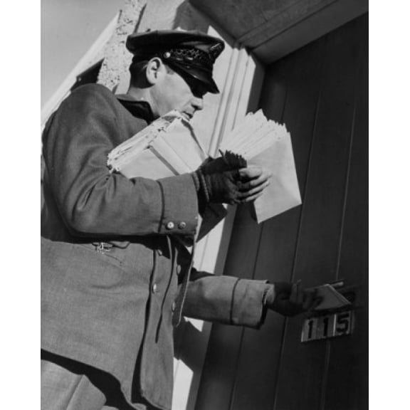 Postman dropping mail in mail slot low angle view Canvas Art -  (24 x 36)