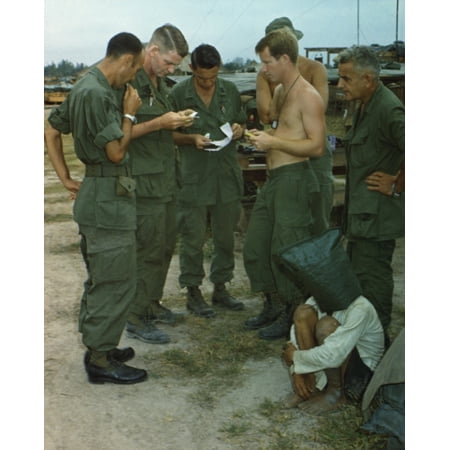 Vietnam War A Suspected Viet Cong Sits On The Ground With A Black Bag Over His Head While Several Us Soldiers Examine Papers He Was Captured During An Attack On An American Outpost Near The Cambodian