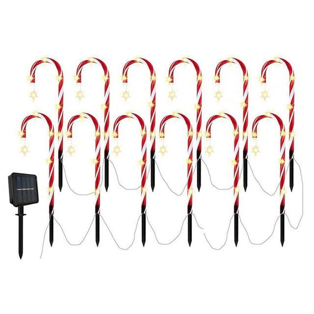 luces solares para el suelo con forma de bastón de navidad, cadena de 12 bastones de caramelo rojos y blancos con estrellas LED amarillas, vista frontal con panel solar en estaca a la izquierda, cables y puntas negras para clavar en césped; también se pueden colgar en árbol o en pared para decoración navideña y paisaje.