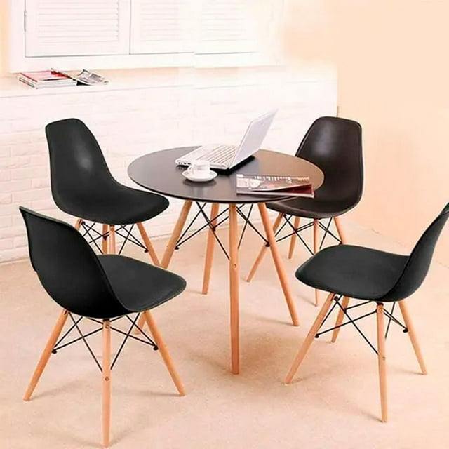 Four modern black wood chairs with light wooden legs arranged around a small round black table, styled as part of the Heavenly Collection Black Wood Chair set.