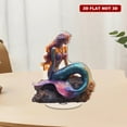 thumbnail image 1 of A rotating acrylic ornament featuring a colorful iridescent mermaid adorned with a necklace sitting gracefully on a rock against a white background, 1 of 8