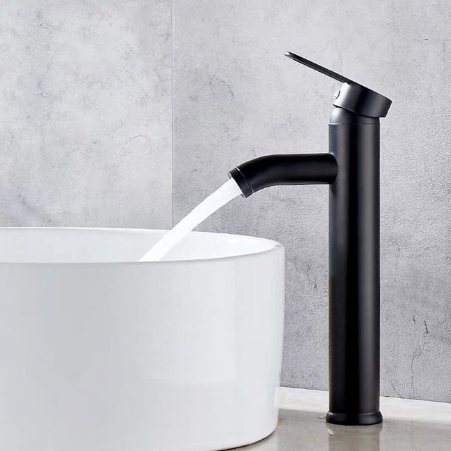 grifo monomando de palanca jamw para lavabo de agua fría y caliente negro 29,5*5cm vista 3/4 de grifo monomando JAMW negro para lavabo, 29.5 cm de altura y base de 5 cm, instalación de un solo orificio; cuerpo cilíndrico alto con caño curvo y manija única superior, válvula de cerámica, mezcla de agua fría y caliente, acabado barniz negro, chorro en funcionamiento sobre lavabo de cerámica. Suele usarse en lavabos sobre encimera por su altura.