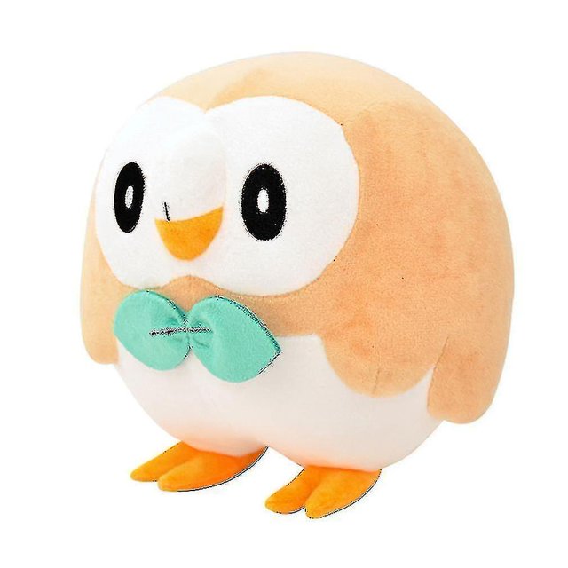muñeco de peluche rowlet pokemon de 25 cm hy Peluche Rowlet redondeado de 25 cm, vista 3/4 frontal con cuerpo beige y vientre blanco, ojos bordados negros y blancos, pico y patas amarillas y moño verde cosido; felpa suave, ideal como peluche para niños o decoración del hogar.