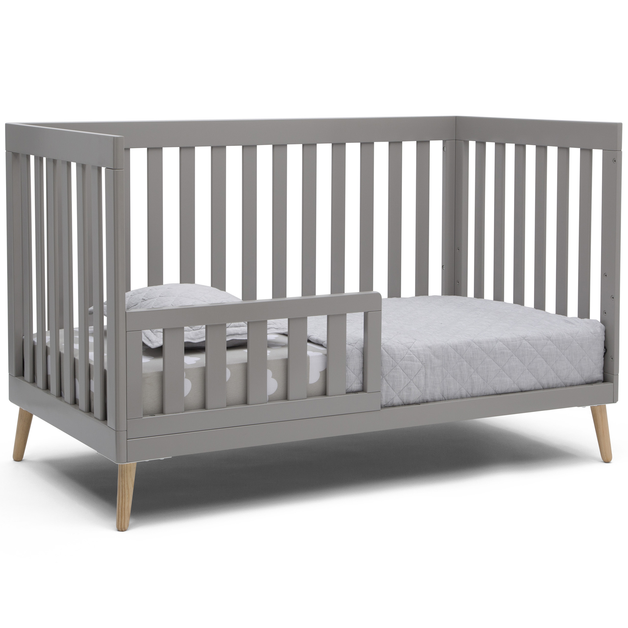 white crib with natural wood legs