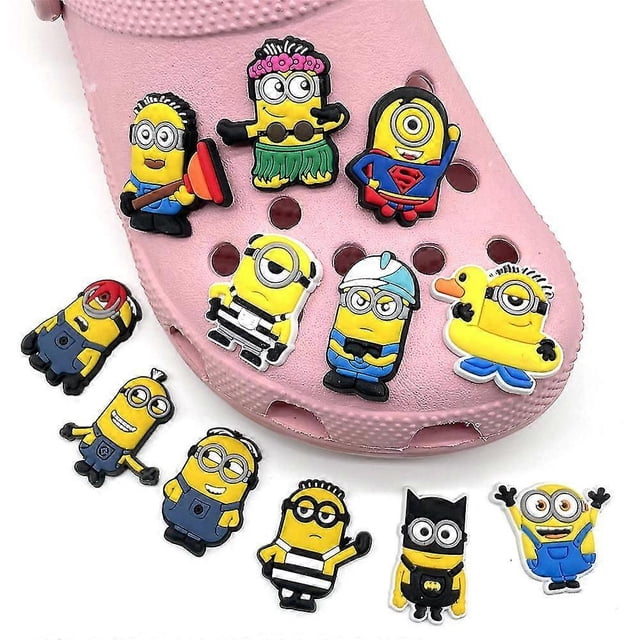 12pcs minions despicable me shoe decoration charms for kids adults crocs shoes diy accessories Conjunto de 12 dijes tipo Minions en PVC sobre un zapato Crocs rosa, vista frontal; figuras amarillas con ojos sencillos o dobles y lentes, atuendos variados (hula, súper héroe estilo S, flotador, uniforme a rayas, casco, estilo murciélago), detalles en negro, azul y rojo y clavija inferior para insertar en los orificios de los Crocs. También aptos para decorar mochilas o pulseras.