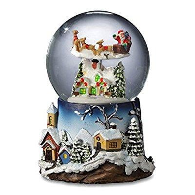 santa flying over village snow globe