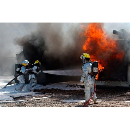 New Airman Battle Uniform - Airman looks on as fellow firefighters rush in to battle a blaze Poster Print by Stocktrek Images
