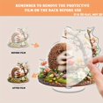 thumbnail image 3 of Rotating acrylic ornament featuring a colorful hedgehog enjoying an apple amidst detailed grass and vibrant flowers. Perfect decorative piece, 3 of 7