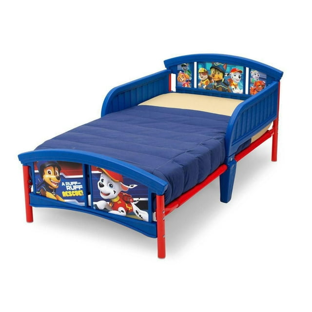 Nick Jr. PAW Patrol toddler bed by Delta Children in blue and red plastic, decorated with character images on headboard and footboard, includes beige mattress and navy quilt.