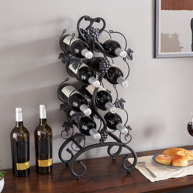 estante de vino metálico independiente negro | portavinos de encimera de 4 niveles con patrón de uva, recubrimiento en polvo resistente al óxido y capacidad para 8 botellas (66,5x30x18cm). Vista frontal 3/4 que muestra estructura curvada de metal, anillas soporte para botellas y detalles de hojas y racimos, colocado sobre encimera de madera junto a botellas y copas; también suele usarse como soporte decorativo portátil para cocina o barra.