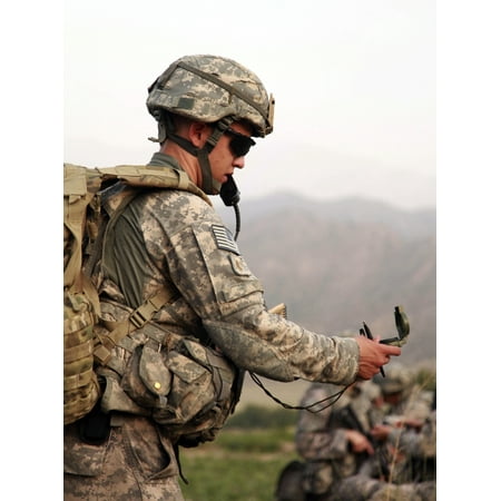 July 28 2009 - US Army soldier checks his compass to be sure of his units direction of travel during an air assault mission in the Khost province of Afghanistan Poster