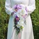 thumbnail image 1 of Simulación de novia de boda con gotas de agua sosteniendo flores Fotografía de boda al aire libre Ramo de flores Diseño de campo de boda, 1 of 5
