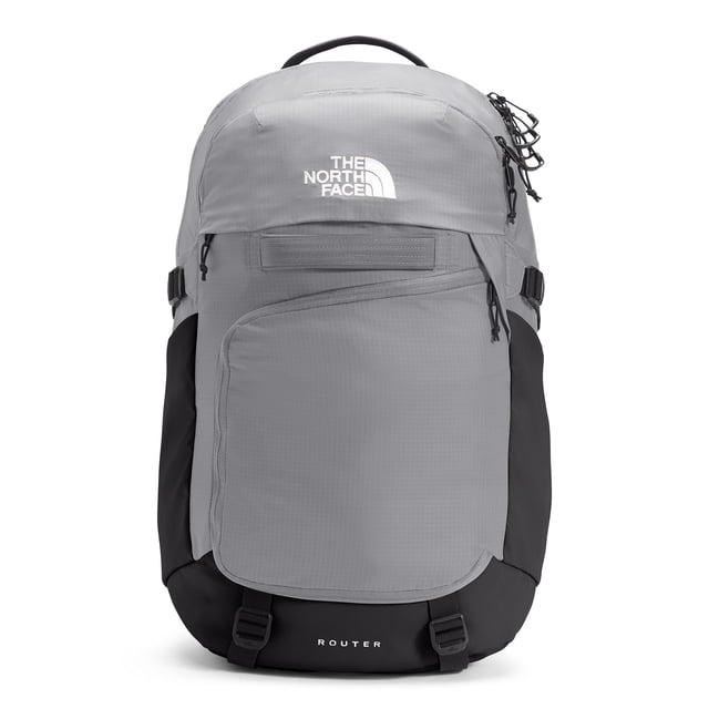 mochila the north face router 35l para hombre meld grey/tnf black frontal, vista centrada de la mochila gris meld con base y costados negros, logotipo blanco en la tapa, gran compartimento principal con cremallera, bolsillo organizador frontal forrado en polar, correas laterales ajustables y asa superior; diseñada para laptop 17" y uso diario o viajes cortos, también suele usarse para organizar equipo técnico ligero.