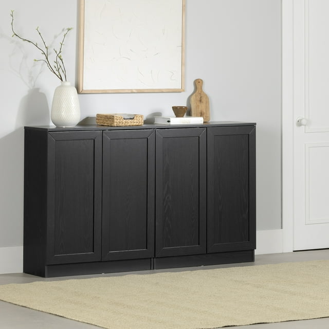 South Shore Arum Ensemble de 2 Buffets avec Tablettes en Chêne Noir avec Quatre Portes de Style Shaker avec Fini Chêne Noir Mat sur une base de podium, Placé dans une Pièce Gris Pâle avec un Tapis beige et Décoré d'Un vase Blanc Tenant des branches, d'Un Panier Tressé, d'Un Livre, d'Un Petit Bol et d'Une Planche à Découper en Bois, Convient au Rangement Organisé de la Cuisine et de la Salle à Manger.
