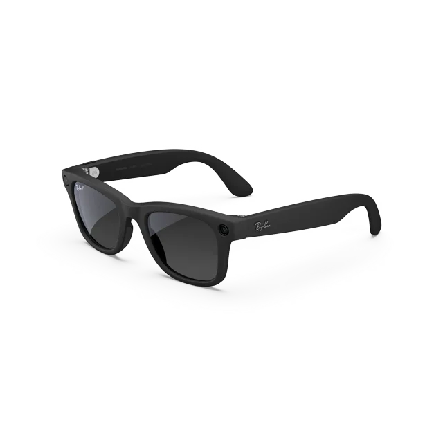 Ray-Ban Meta Wayfarer (Gen 2) Smart Glasses in matte black with gradient graphite polarized lenses, combining wearable technology with AI for photo, video, audio, and messaging. Features include discreet open-ear speakers, ultra-wide 12MP camera, hands-free Meta AI functionality, and live translation. Designed with a standard size and high bridge fit, shown alongside a charging case and cable.