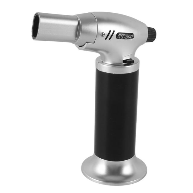 encendedor de antorcha recargable a prueba de viento, llama ajustable, mini soplete con cerradura de seguridad para camping, cocina, vela, barbacoa — Soplete de mano con cuerpo cilíndrico negro y base ancha plateada, cabeza de aleación plateada y boquilla tubular; perilla trasera para ajuste de llama y bloqueo lateral visibles; tamaño aprox. 13.8x10.5x5.4 cm, peso aprox. 142 g. Uso para asar, hornear y soldar; a menudo usado también para caramelizar postres.