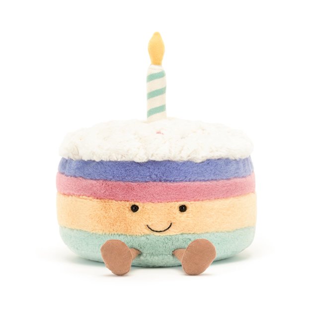 jellycat amuseables rainbow birthday cake stuffed toy, large 10 inches | dessert plush | birthday gift — centered front-facing studio shot of a round, multicolor plush cake with pastel layers (mint, peach, pink, lavender), white confetti-style top, embroidered smile and black bead eyes, two small brown felt feet and a striped candle on top; collectible plush suitable as a birthday gift.