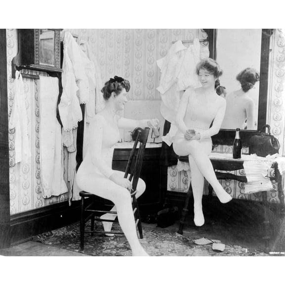 Print: Two Young Women, Wearing Long Underclothing, One Seated On Chair