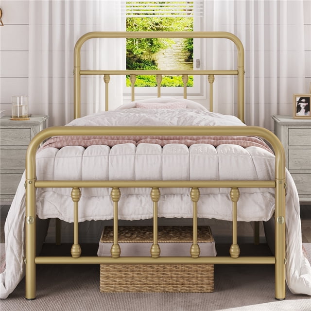 Twin antique gold metal platform bed with high headboard and footboard, styled with white bedding in a bright bedroom.