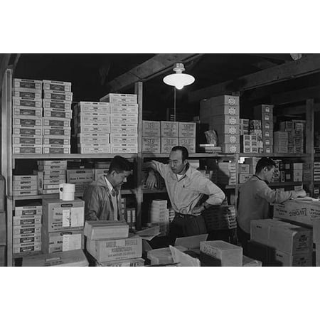M Ogi S Sugimoto and Bunkichi Hayashi standing among shelves with boxes in warehouse  Ansel Easton Adams was an American photographer best known for his black-and-white photographs of the American