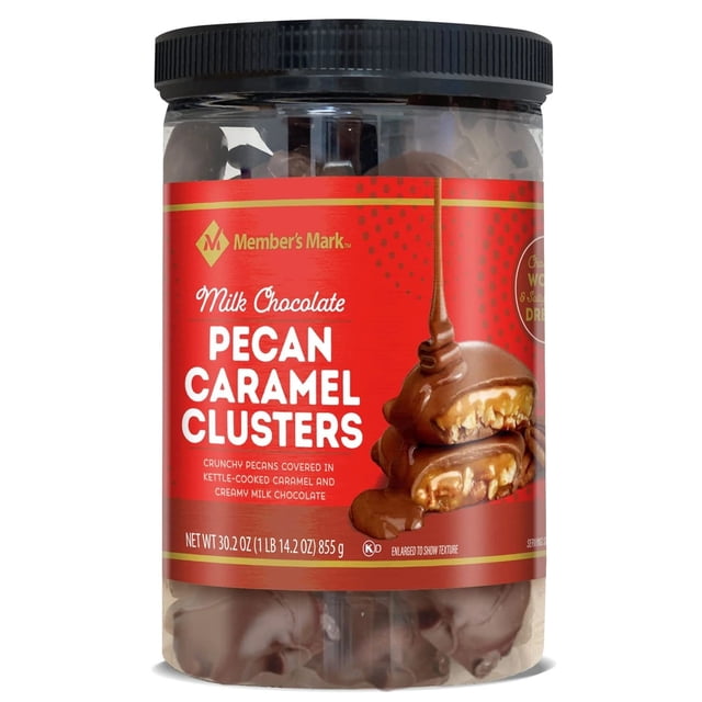 member's mark milk chocolate pecan caramel clusters, 30.2 ounce, 1.88 pound (pack of 1) Frasco frontal centrado transparente con tapa negra que muestra clusters de pacana cubiertos de chocolate; etiqueta roja con texto blanco y una imagen de cluster partido con caramelo goteando; peso neto 30.2 oz (855 g).