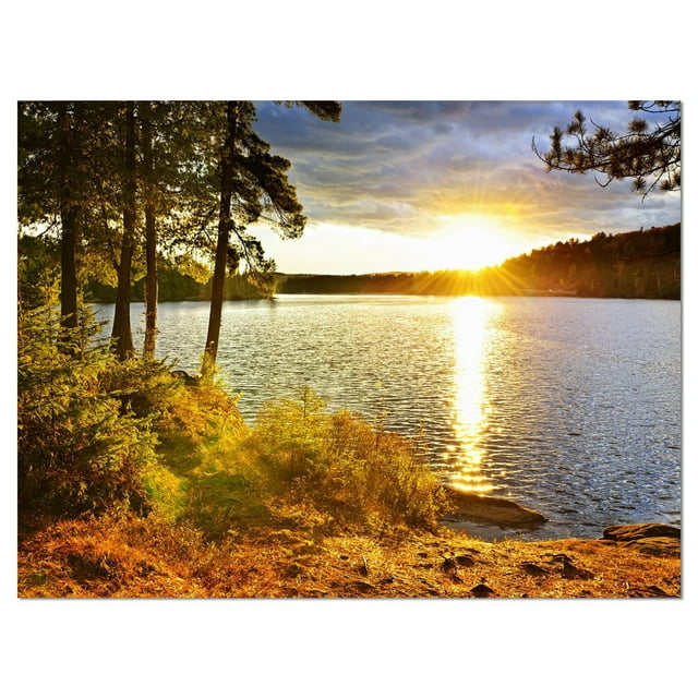 Designart Beautiful View of Sunset over Lake Canvas Wall Art featuring a landscape of a sun setting over a calm lake with green trees and foliage along the shore, printed on premium cotton canvas with gallery-wrapped edges, ready to hang as decorative wall art.