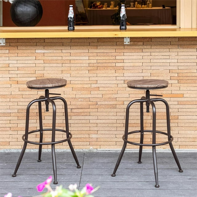 Pair of Homy Casa adjustable swivel barstools with moisture-resistant walnut finish MDF seats and black metal frames, featuring footrests, set on an outdoor patio.
