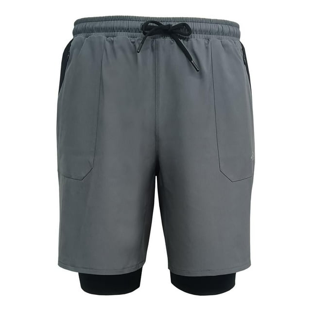 Bermuda Umbro para Hombre Talla M Gris, short deportivo gris con licra interna negra visible en la parte inferior, cintura elástica con cinta ajustable y cordón negro, bolsillos laterales con cierre para seguridad, logo Umbro en pierna derecha, resistente y cómodo para actividades deportivas y al aire libre, también adecuado para senderismo y camping.