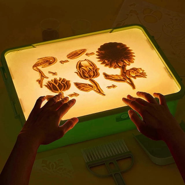 light table for kids-sand painting light box sand art light table toys for boys and girls Verde 14.9"x11.22" caja de luz rectangular con superficie translúcida iluminada, vista frontal con dibujos florales en arena sobre luz amarilla cálida; carcasa de plástico verde, perilla frontal para 3 modos de luz y 5 niveles de brillo, herramientas de arena visibles y manos de niño tocando la superficie; a menudo usada para actividades creativas y de coordinación motora.