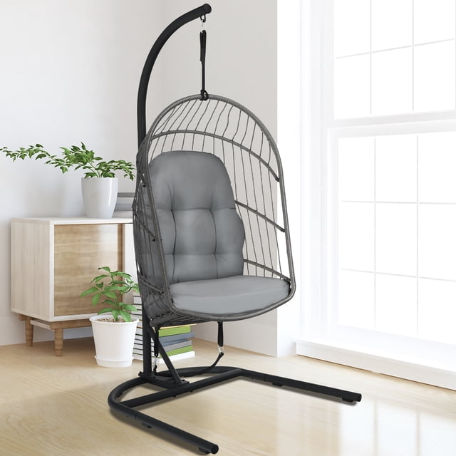 Costway Fauteuil Oeuf Suspendu en Osier avec Support et Coussin, Gris, Présenté dans un Cadre Intérieur. le Fauteuil Présente un Panier Pliable en Rotin PE Soutenu par un Cadre Robuste en Acier Noir avec une base de Type C et une Sangle de Sécurité. Comprend des Coussins Épais Rembourrés pour le Confort et une Capacité de Charge de 330 Lb.