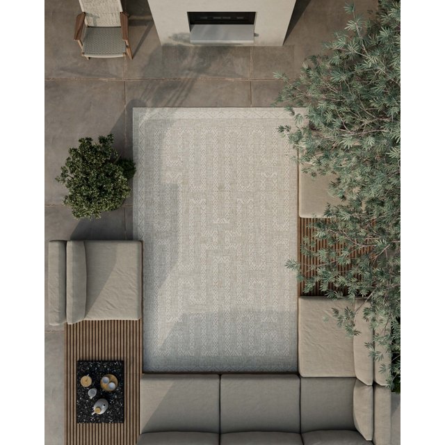 neutral-toned ECARPET Maze Transitional Area Rug with geometric maze design on outdoor patio featuring beige cushioned seating, greenery, and modern fireplace
