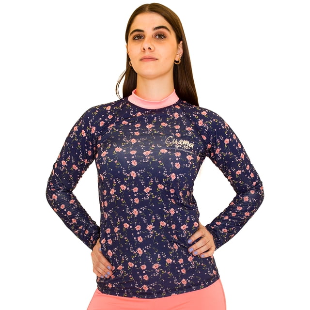playera manga larga para dama con protección solar upf50+ azul marino con estampado floral rosa, cuello redondo rosa y mangas ranglan; corte ajustado que permite movilidad, logo CUSMA en el pecho, poliéster resistente al cloro y al agua salada, fondo blanco con modelo de frente; también es adecuada para actividades acuáticas y deportes al aire libre.
