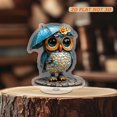 thumbnail image 6 of Rotating acrylic ornament featuring a colorful glass owl with a rain hat and umbrella, wearing a cyan raincoat on a cobblestone road, 6 of 8