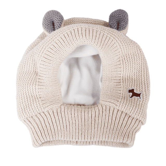 orejeras para mascotas, protección auditiva para perros en invierno envoltura cálida para la cabeza protección para mascotas del ruido y la ansiedad. Gorro beige de punto con forro interior blanco suave y abertura frontal para el hocico; base con ribete elástico, dos orejas tejidas grises en la parte superior y parche con silueta de perro marrón en el costado. Ideal para mantener al perro abrigado y ayudar a reducir la ansiedad por ruidos durante paseos, baños o sesiones de corte de uñas.